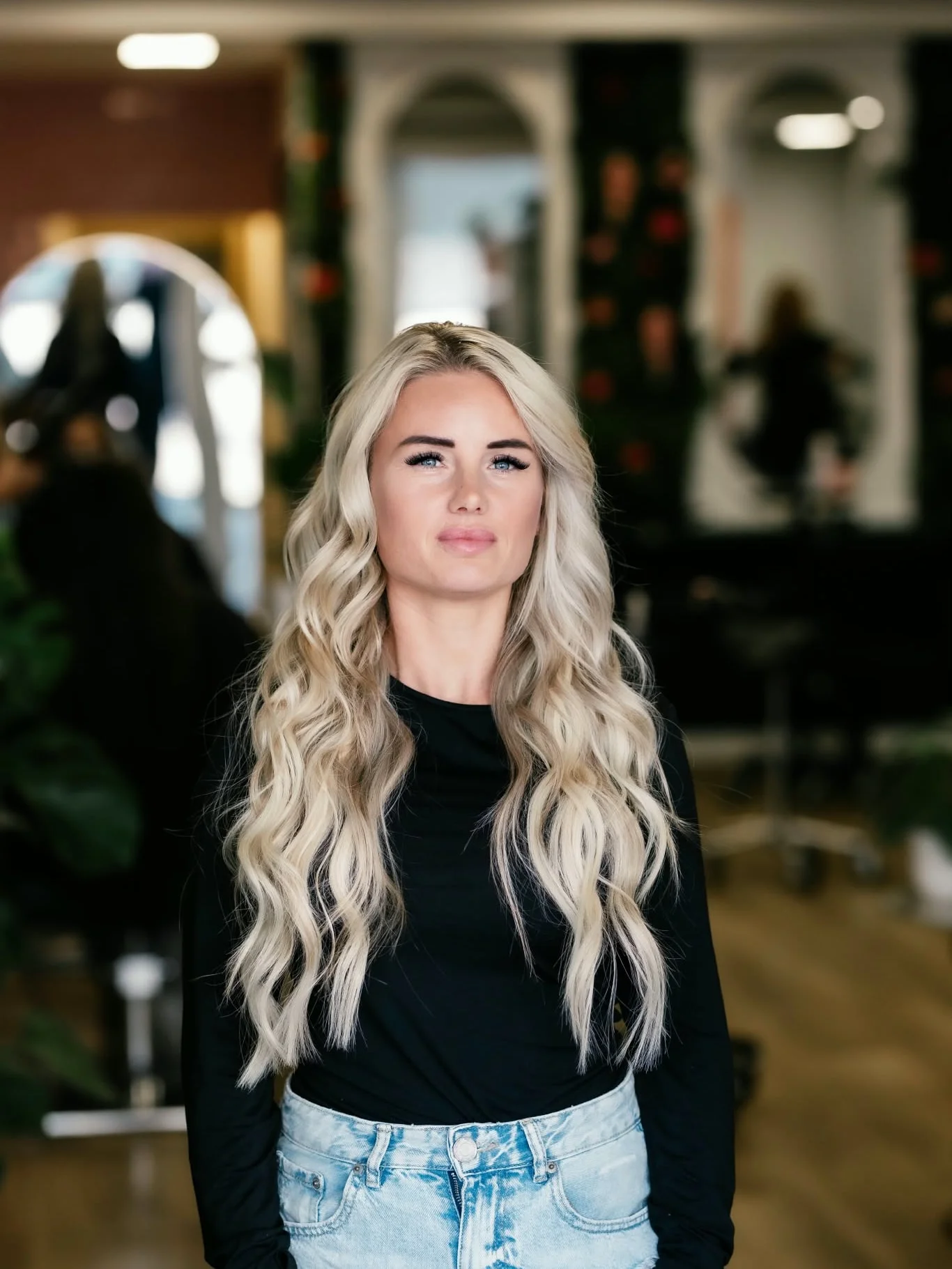 Klant met lang, golvend blond haar, van voren gezien in de salon