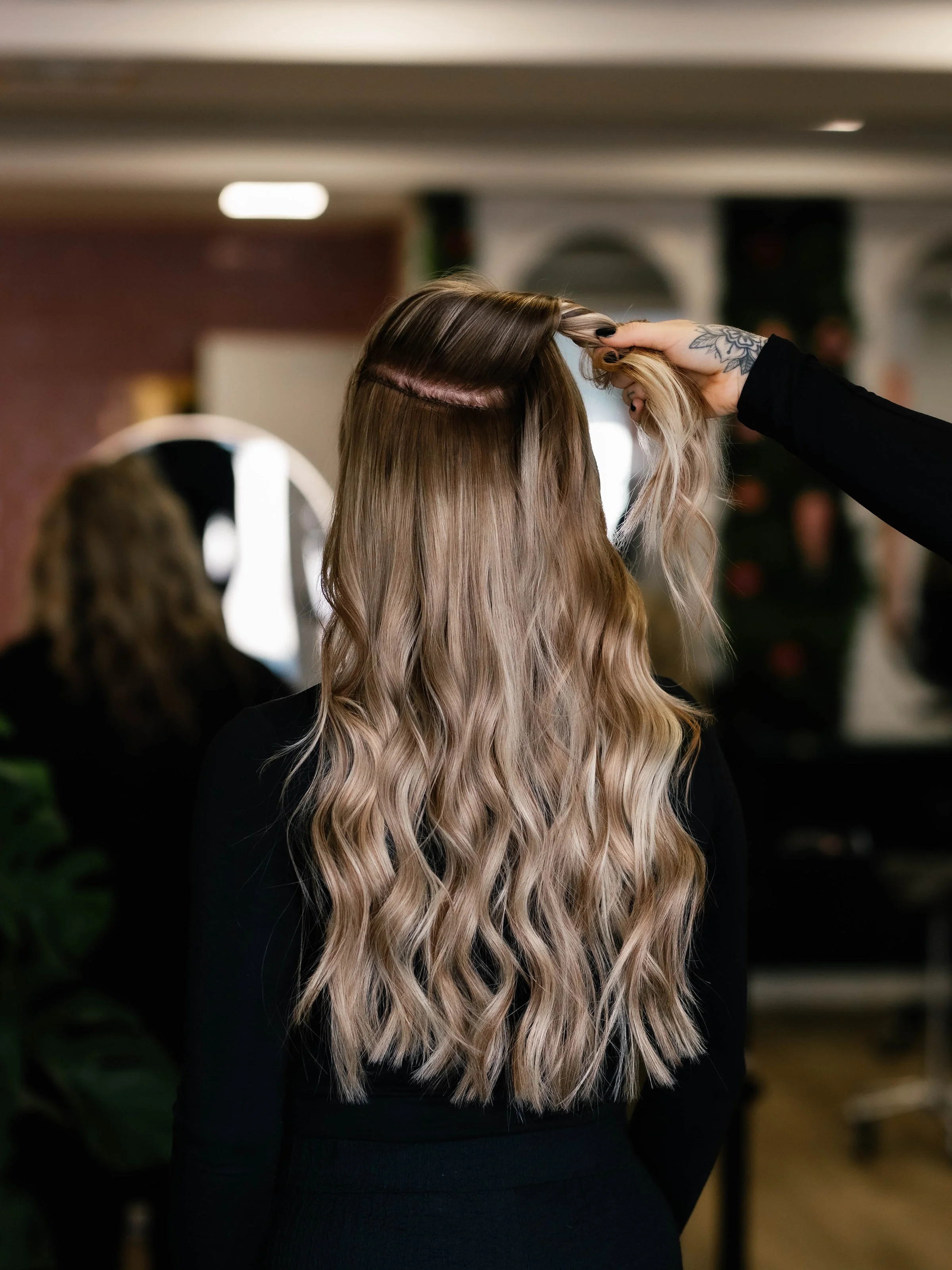 Stylist tilt het bovenhaar op en laat zien waar de weft zit