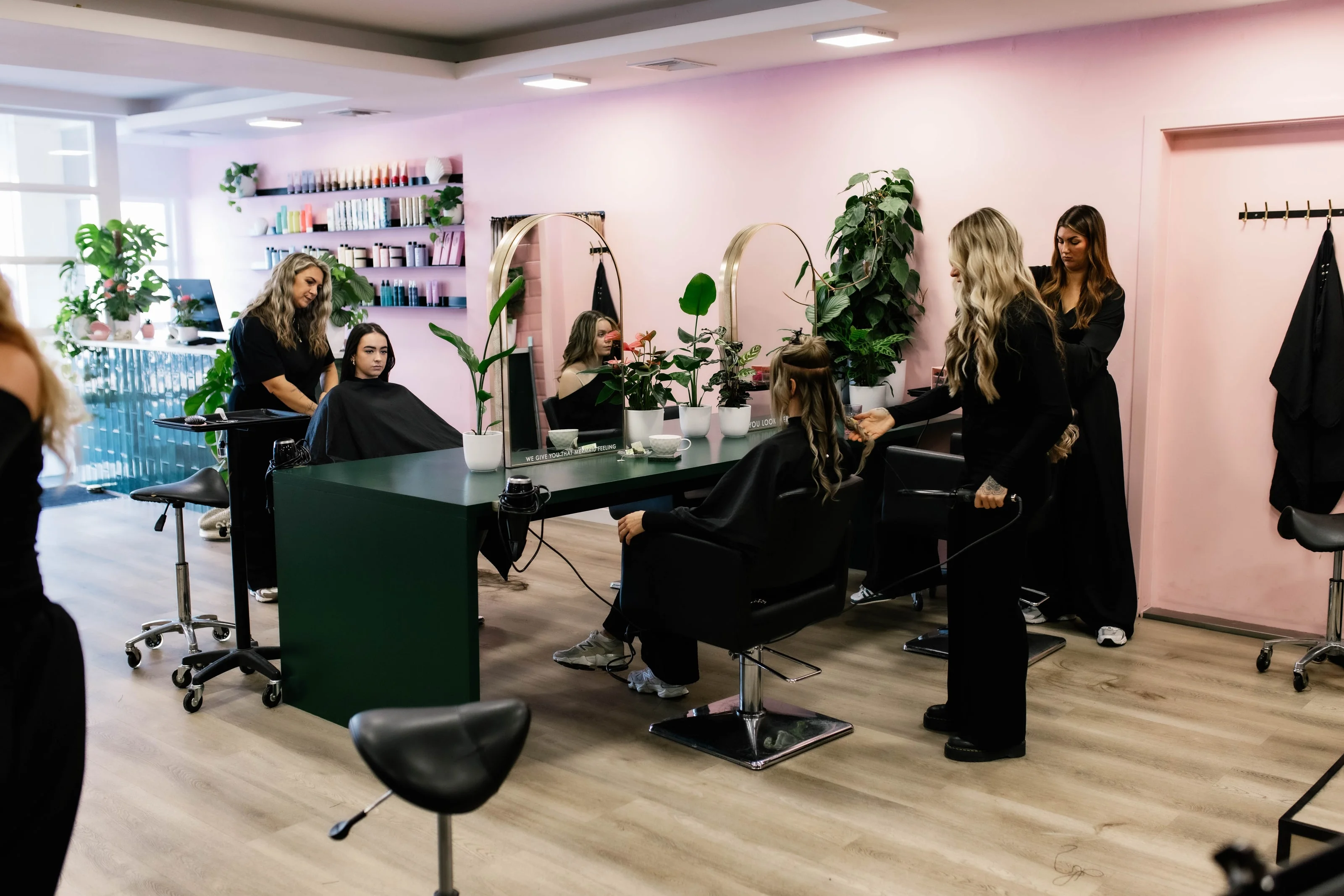 Stylisten aan het werk bij klanten in de roze salon