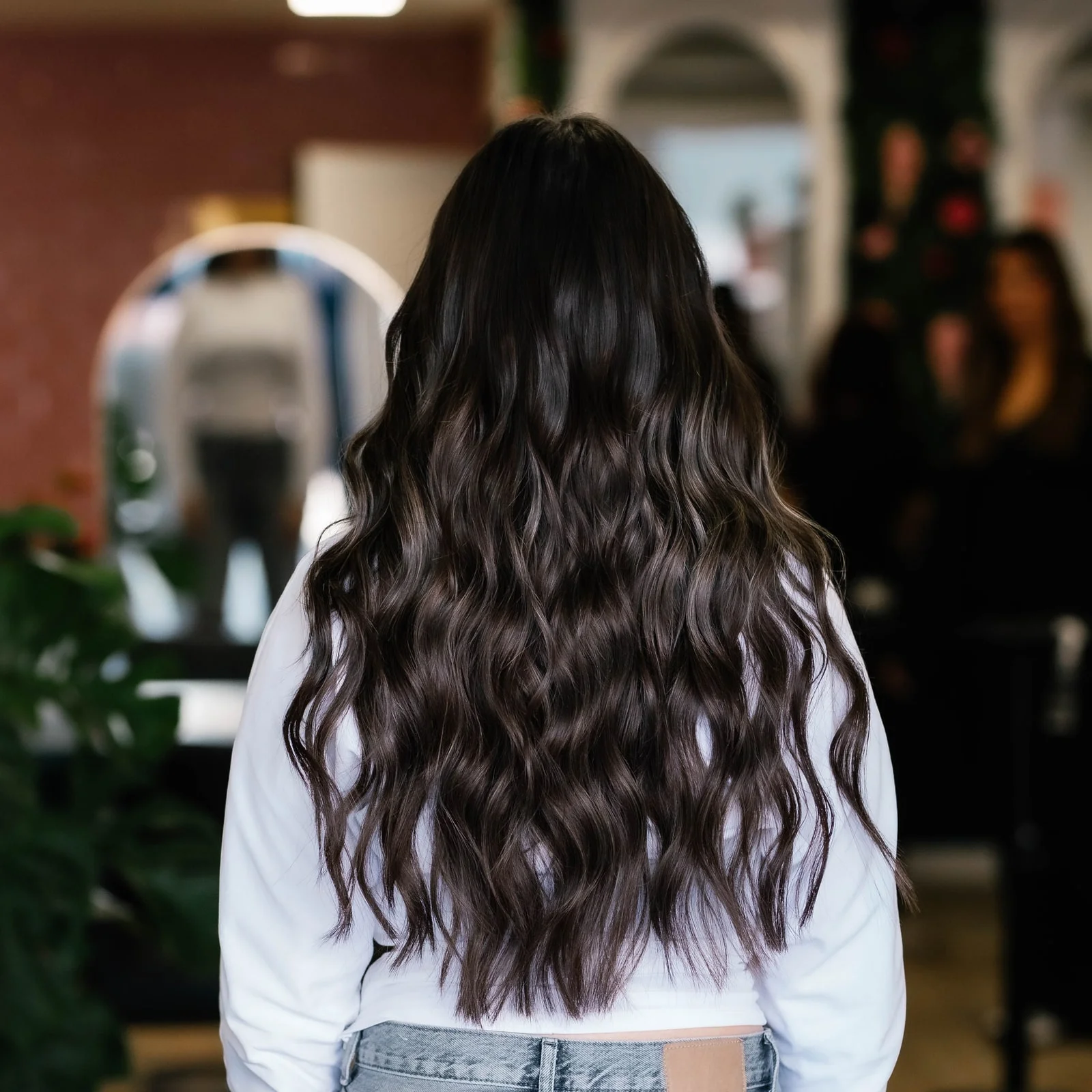 Dezelfde klant met voller, golvend donker haar na het zetten van extensions