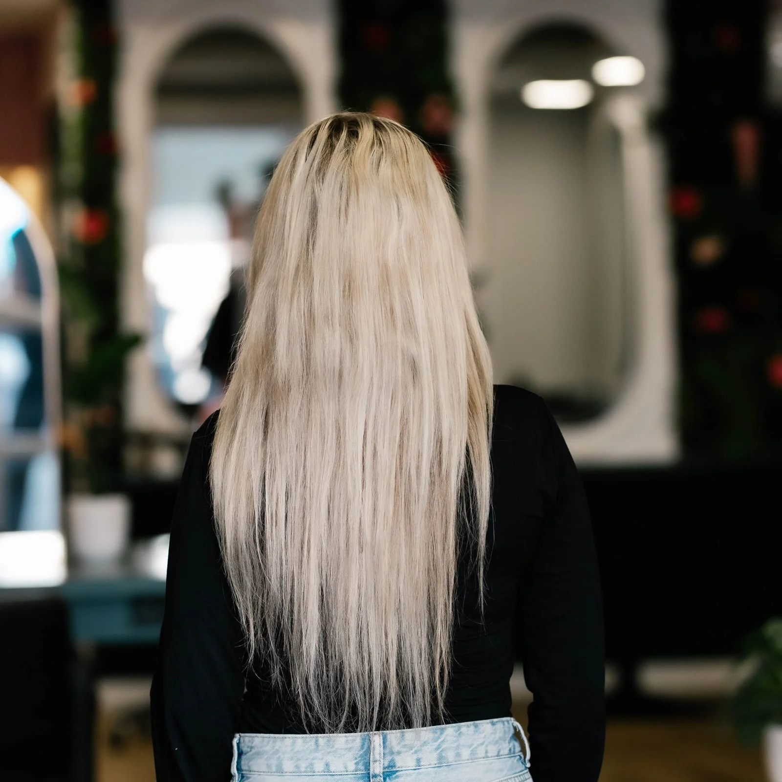 Klant met steil, lang blond haar, van achteren gezien, voor de behandeling